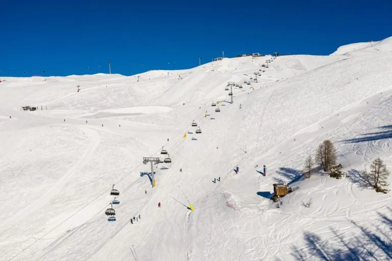 Vista aerea della stazione sciistica di Crans-montana e della seggiovia in una soleggiata giornata invernale sulle Alpi svizzere, nel Vallese, in Svizzera.
