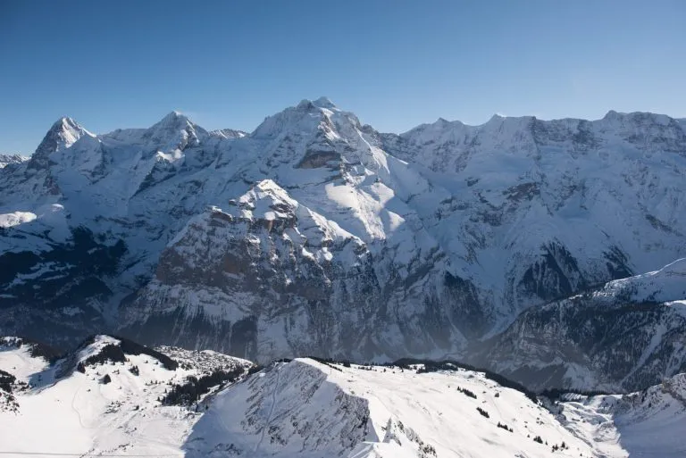 the famous mountains in switzerland eiger monk and jungfrau, below in the picture the mountain village mürren which can be reached only with the aerial cableway ore walking.