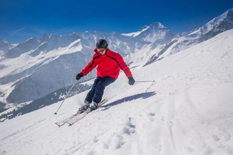 Junger glücklicher Mann beim Skifahren im Skigebiet Lenzerheide, Schweiz.