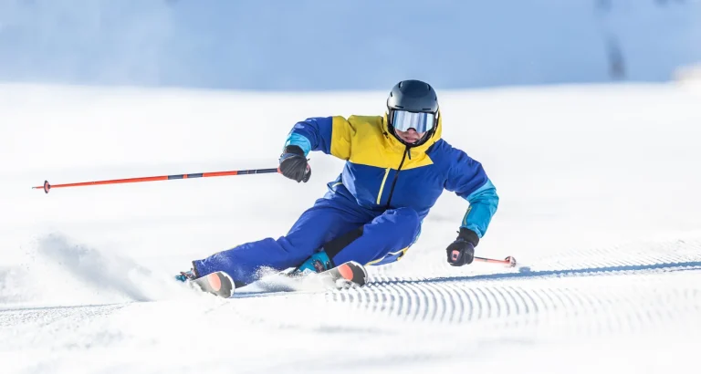 Ein junger aggressiver Skifahrer demonstriert auf einer alpinen Piste einen extremen Carving-Skistil.