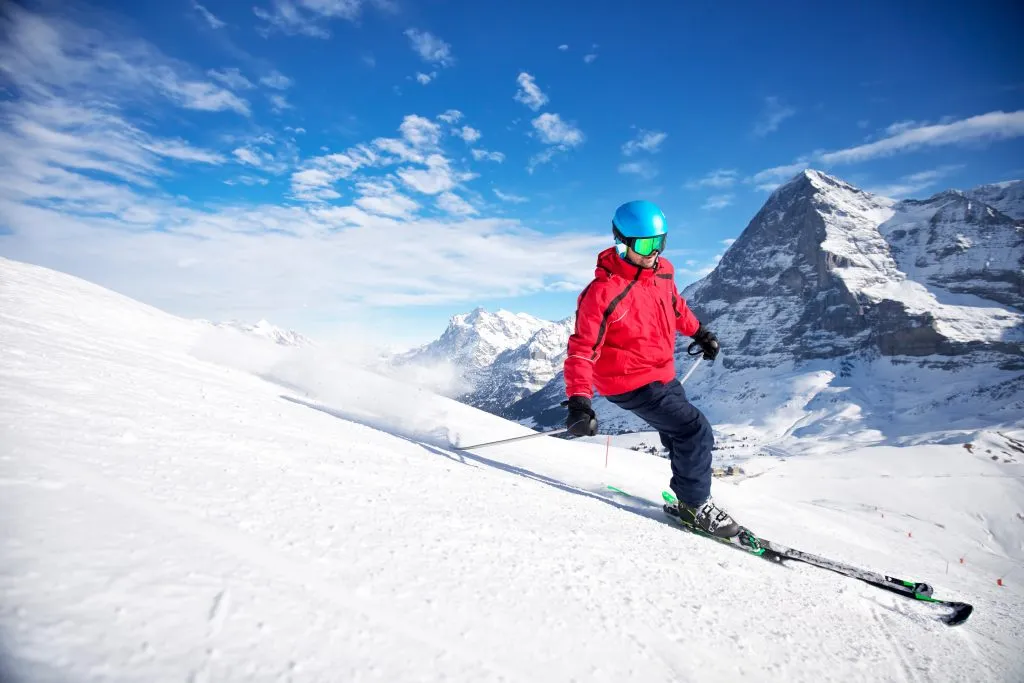 Junge attraktive kaukasische Skifahrerin auf der Skipiste im berühmten Jungfrau-Skigebiet in den Schweizer Alpen, Grindelwald, Schweiz